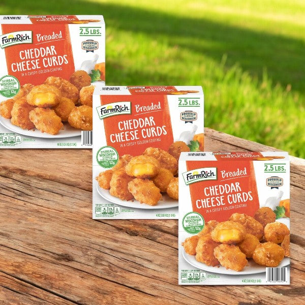 Three boxes of Farm Rich Breaded Cheddar Cheese Curds, 2.5 lbs each, rest on a wooden surface against a grassy backdrop, each box displaying an enticing image of these delicious cheese curds, ideal for snacking or as appetizers.