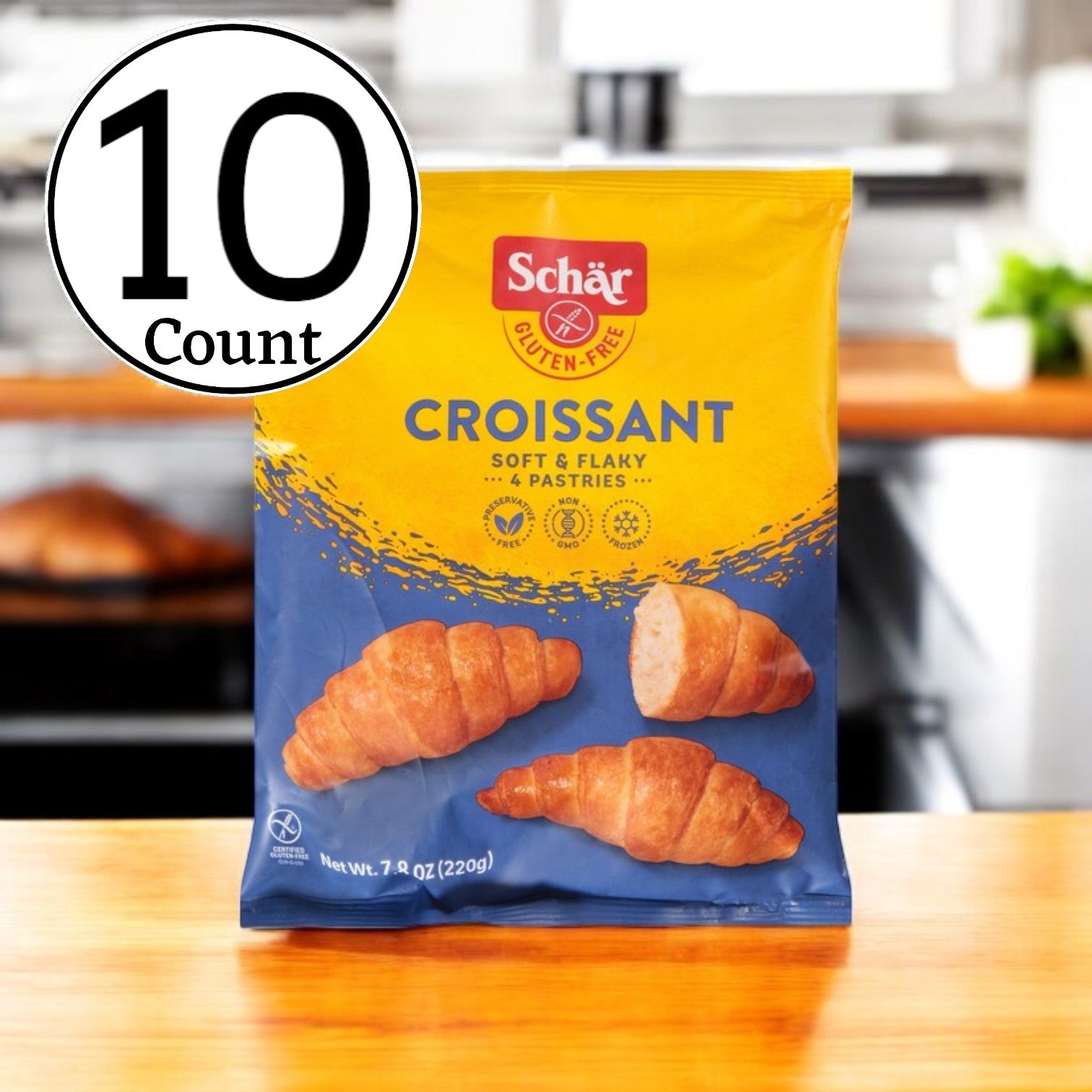 A package of Schar Plain Croissants, celebrated for their flaky texture, is displayed in a kitchen. The label indicates it is part of a case that contains ten pastries in total.