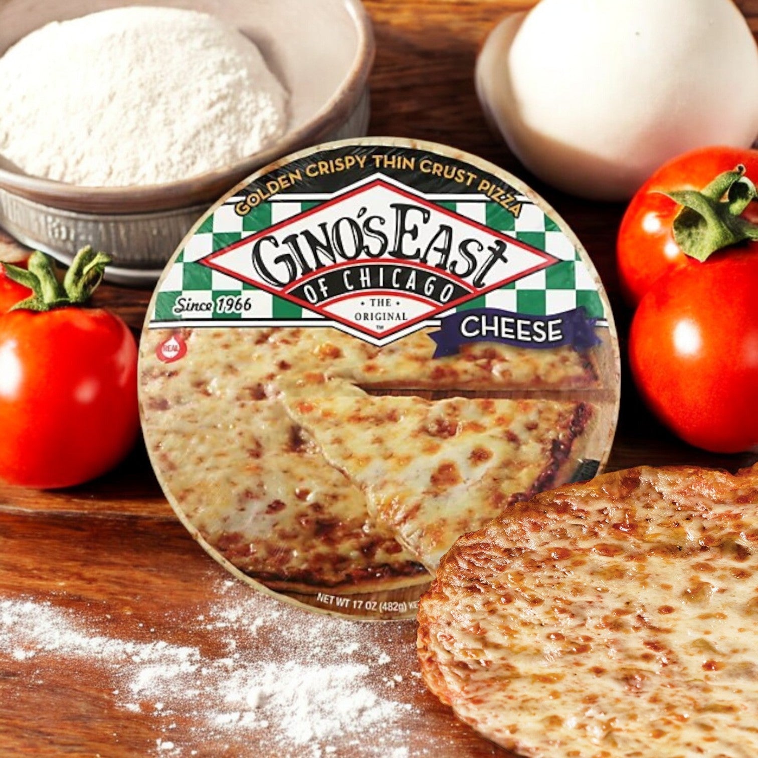 Gino's East of Chicago Golden Crispy Thin Crust Pizza, 15.6 oz, sits enticingly among fresh tomatoes, a mozzarella ball, and a bowl of flour, capturing the essence of authentic Chicago tavern-style pizza.