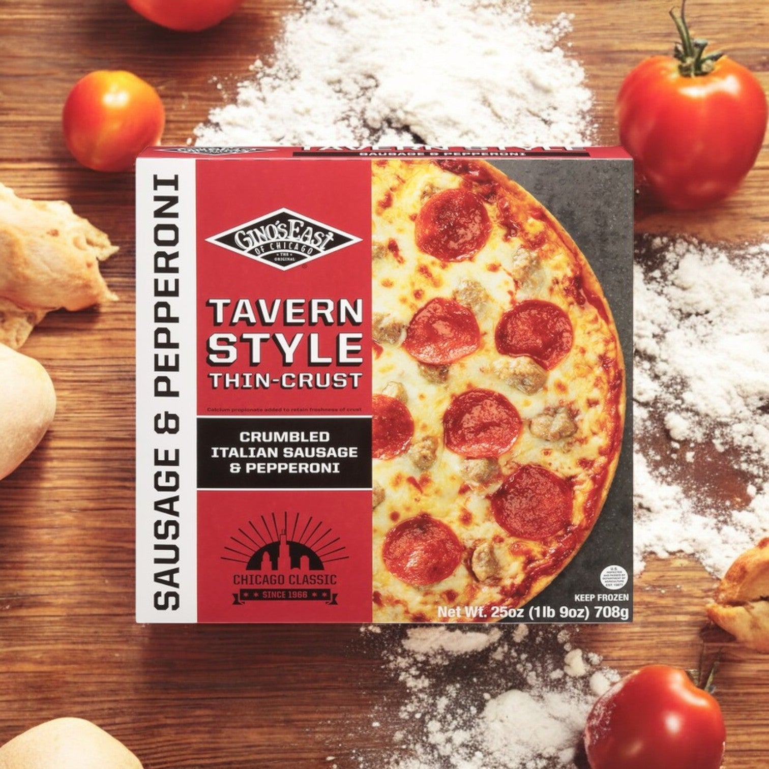 A box of Gino's East Thin Crust Tavern Style Sausage & Pepperoni Pizza, 25 oz - 3 Count (by Gino's East Pizza) is on a wooden surface with tomatoes, fresh dough, and flour. Enjoy the rich sausage and pepperoni flavors on this perfectly crisp creation.