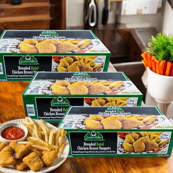 Three boxes of Garden Valley Foods Breaded Halal Chicken Breast Nuggets sit on a kitchen counter, while a plate of crispy nuggets, golden fries, and tangy sauce takes the spotlight in the foreground.
