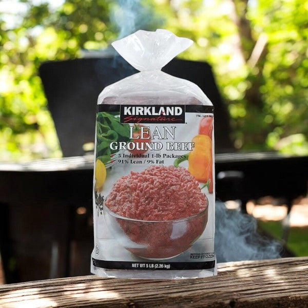 A pack of Kirkland Signature Lean Ground Beef-5 Pounds sits on an outdoor table, with a blurred natural background—perfect for meal prepping.