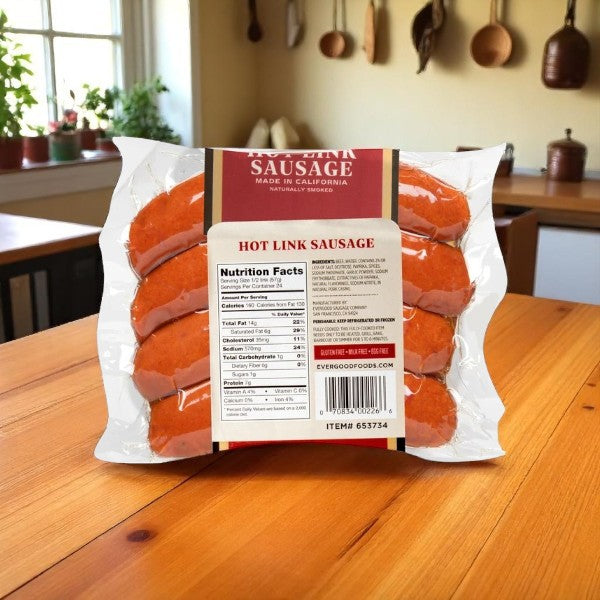 A sealed pack of Evergood Louisiana Brand Hot Link Sausage, 12 Links (3 lbs-1 Pack), rests on a wooden kitchen table with the nutrition facts label visible. Kitchen utensils and cookware hang in the background, highlighting the naturally smoked beef sausages.