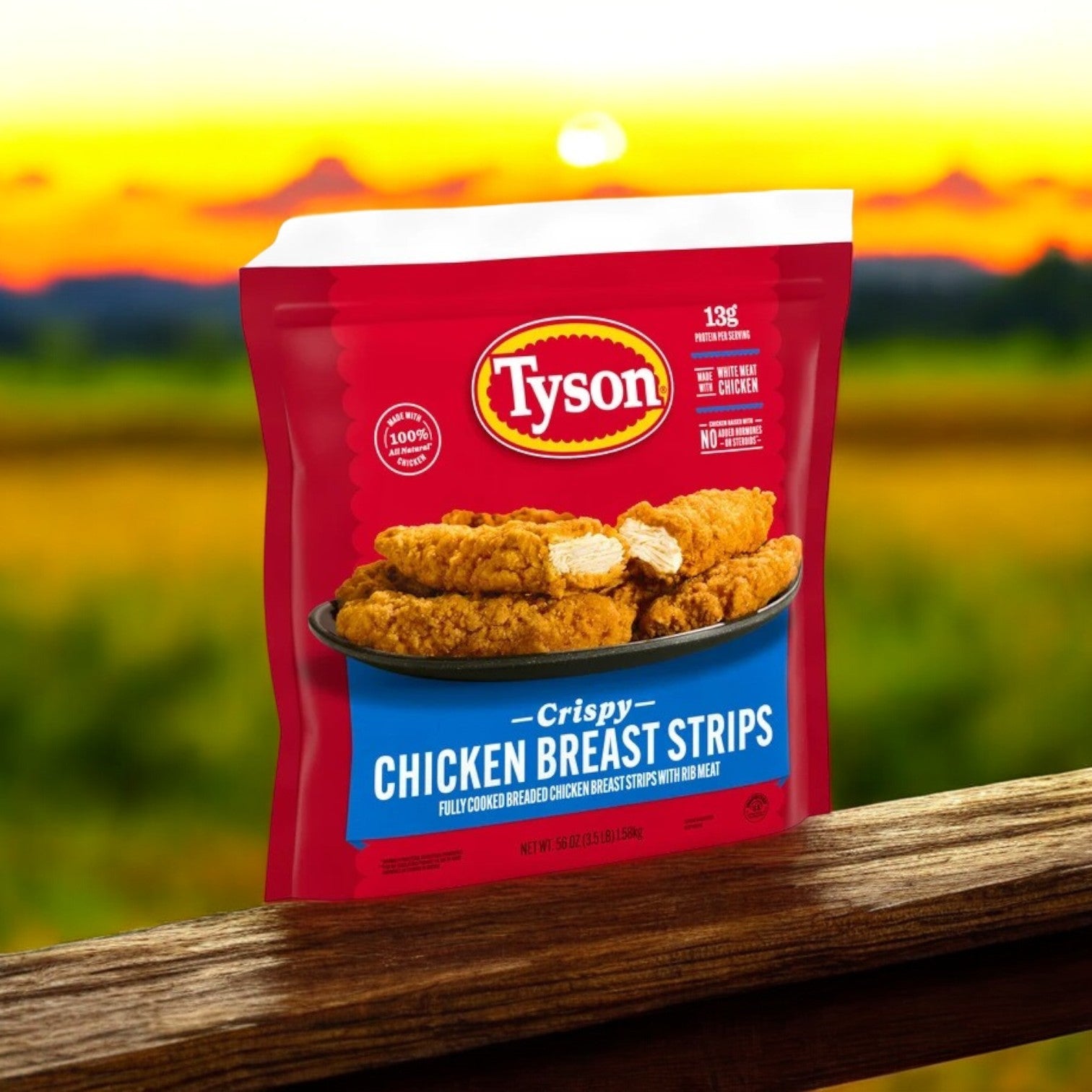 A 3.5 lb. bag of Tyson Fully Cooked Crispy Chicken Strips rests on a wooden ledge, set against a field at sunset.