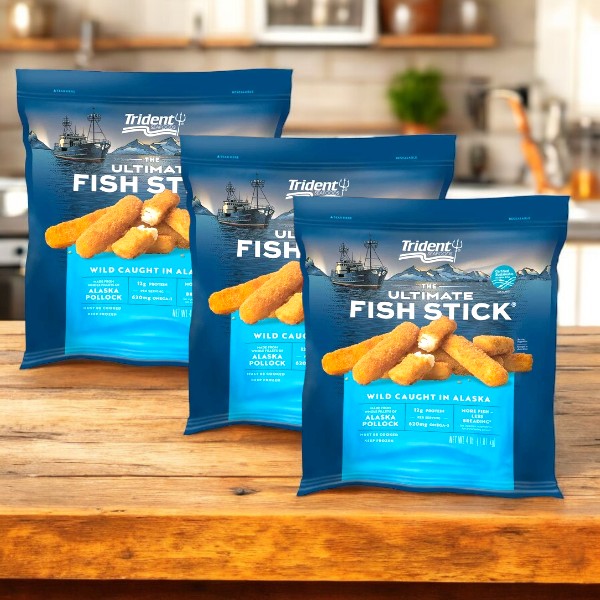 Three packs of Trident Seafoods Panko Breaded Wild Caught Alaska Pollock Fish Sticks (4 lbs each) rest elegantly on a wooden counter, suggesting a delicious seafood choice for any meal.