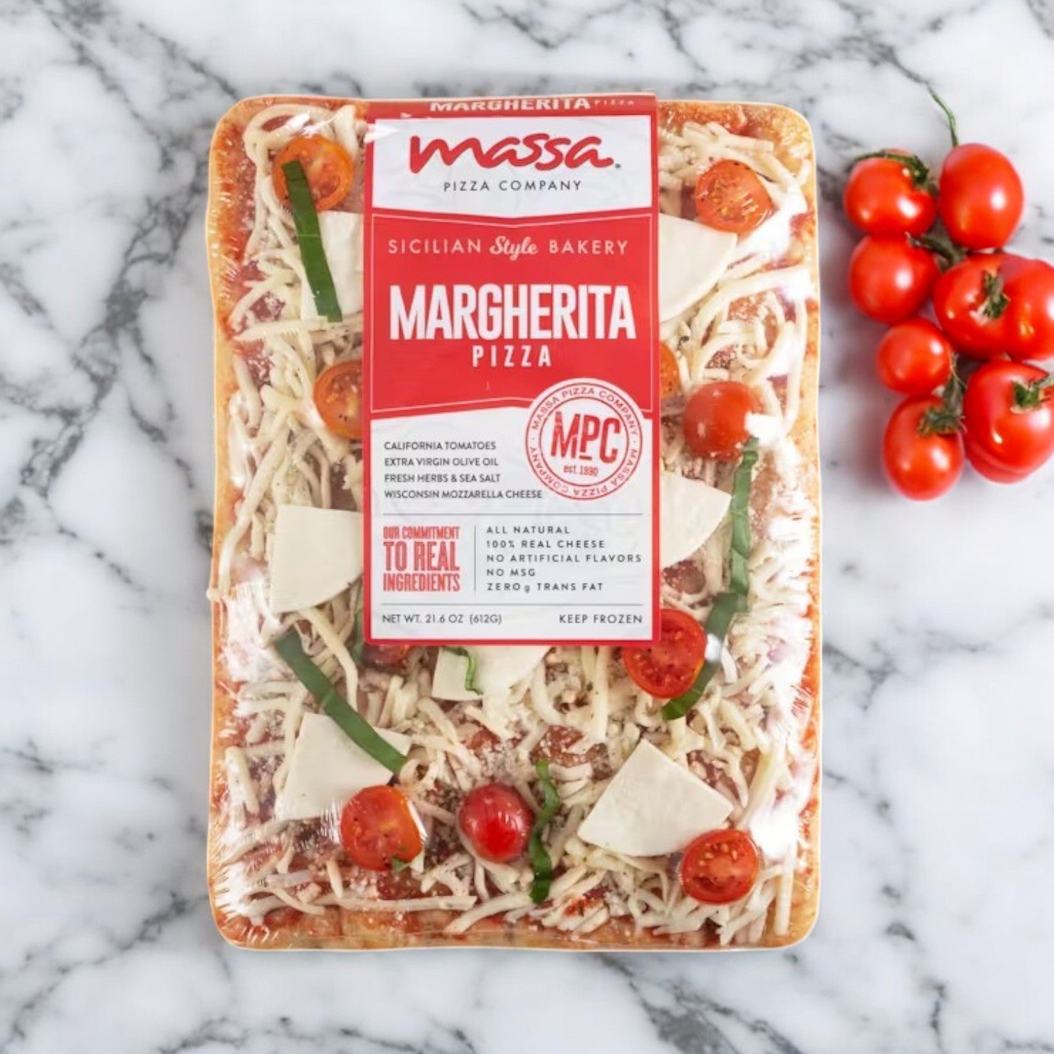 Massa Pizza Co.'s Margherita Bakery Pizza, weighing 21.6 oz., showcases a handcrafted dough prepared on a marble surface, accompanied by an array of fresh cherry tomatoes.