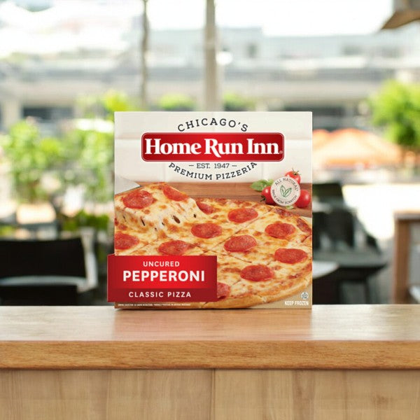 A Home Run Inn Variety Pack labeled "4 Total Pizzas" rests invitingly on a wooden counter, offering a delightful mix of savory goodness topped with creamy mozzarella cheese.
