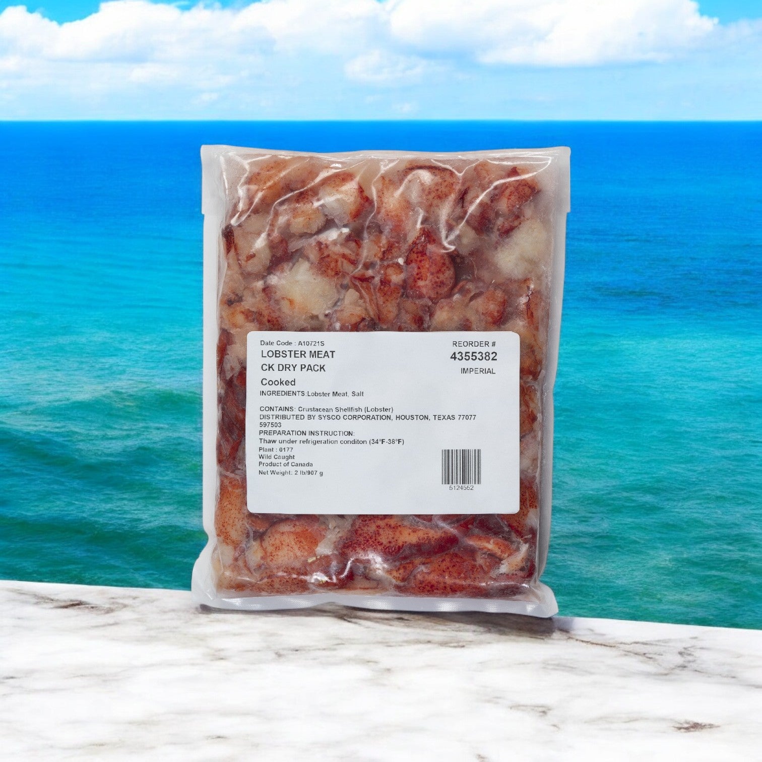 A 2-pound sealed package of Easy Lunches' Maine Lobster Meat Claw and Knuckle rests on a marble surface, set against a serene ocean backdrop.