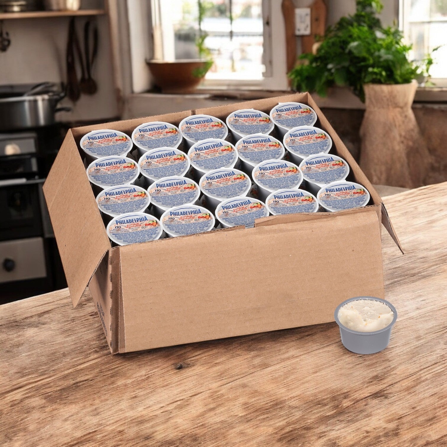 A Kraft Philadelphia Garden Vegetable Cream Cheese 100-pack (1 oz each) sits on a wooden table, with one serving outside the box, highlighting its fresh garden flavor.