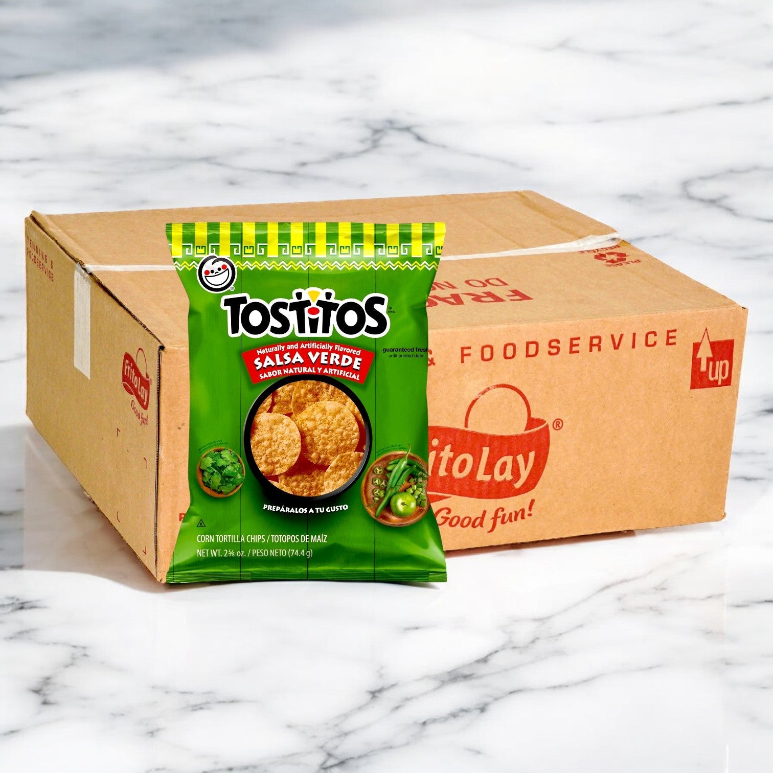 A bag of Tostitos Salsa Verde Tortilla Rounds, featuring a zesty flavor, is set in front of a Frito-Lay cardboard box on a marble surface.