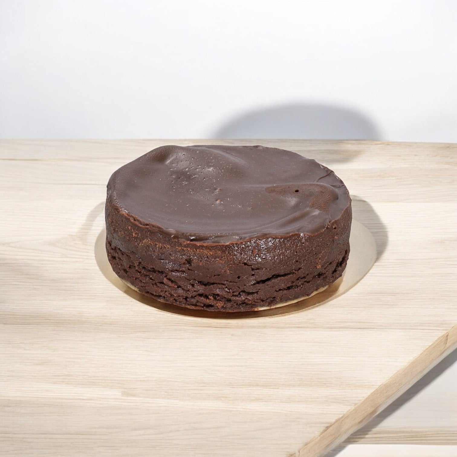 A Sweet Street Cake Chocolate Flourless from a 1-case, 8-pack, 32-count total set rests on a light wooden table against a white background, highlighting its premium ingredients.