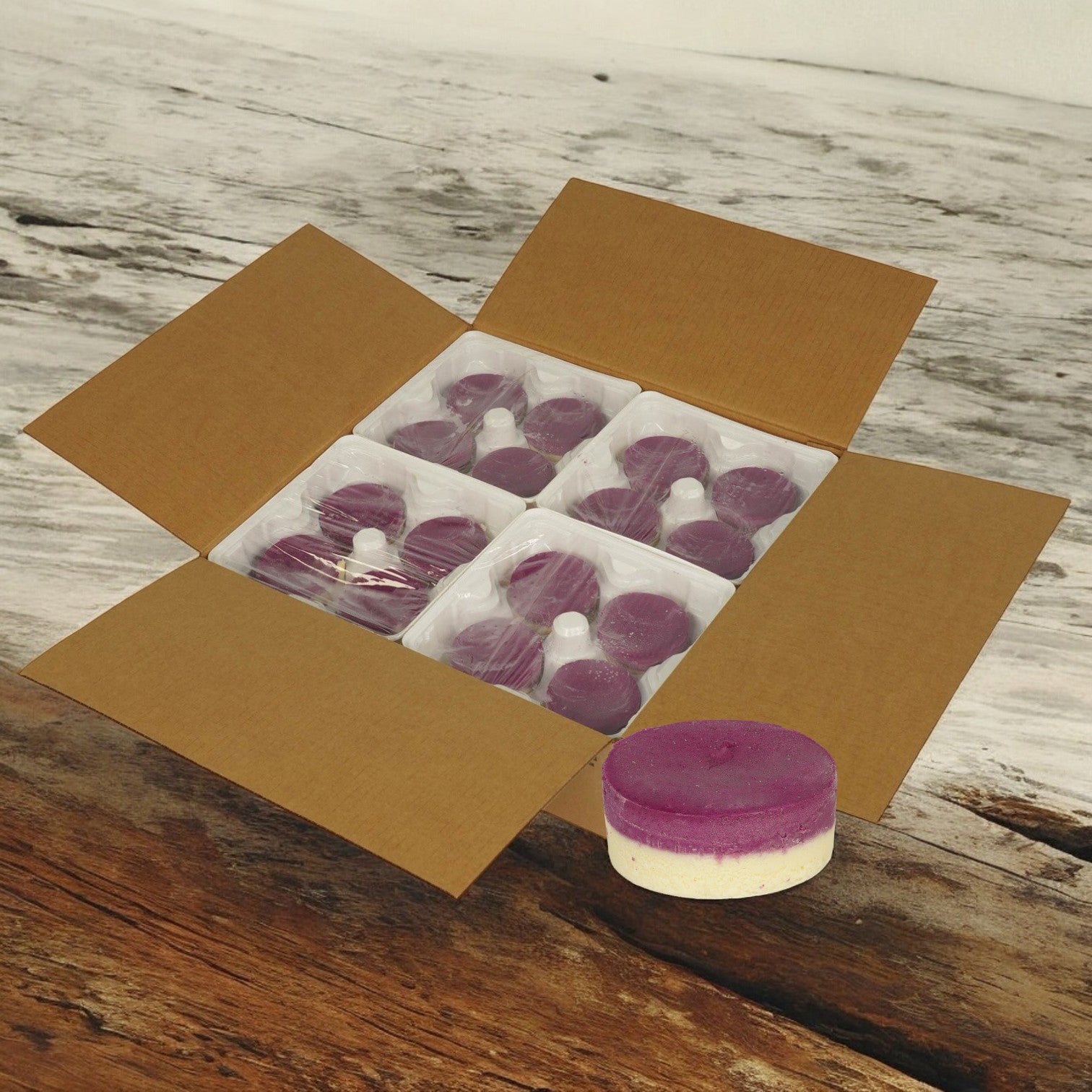 An open box labeled Sweet Street Cheesecake Ube Individual rests on a wooden surface, containing multiple packs of round purple and white pods. One pod, known for its premium ingredients, lies outside the box.