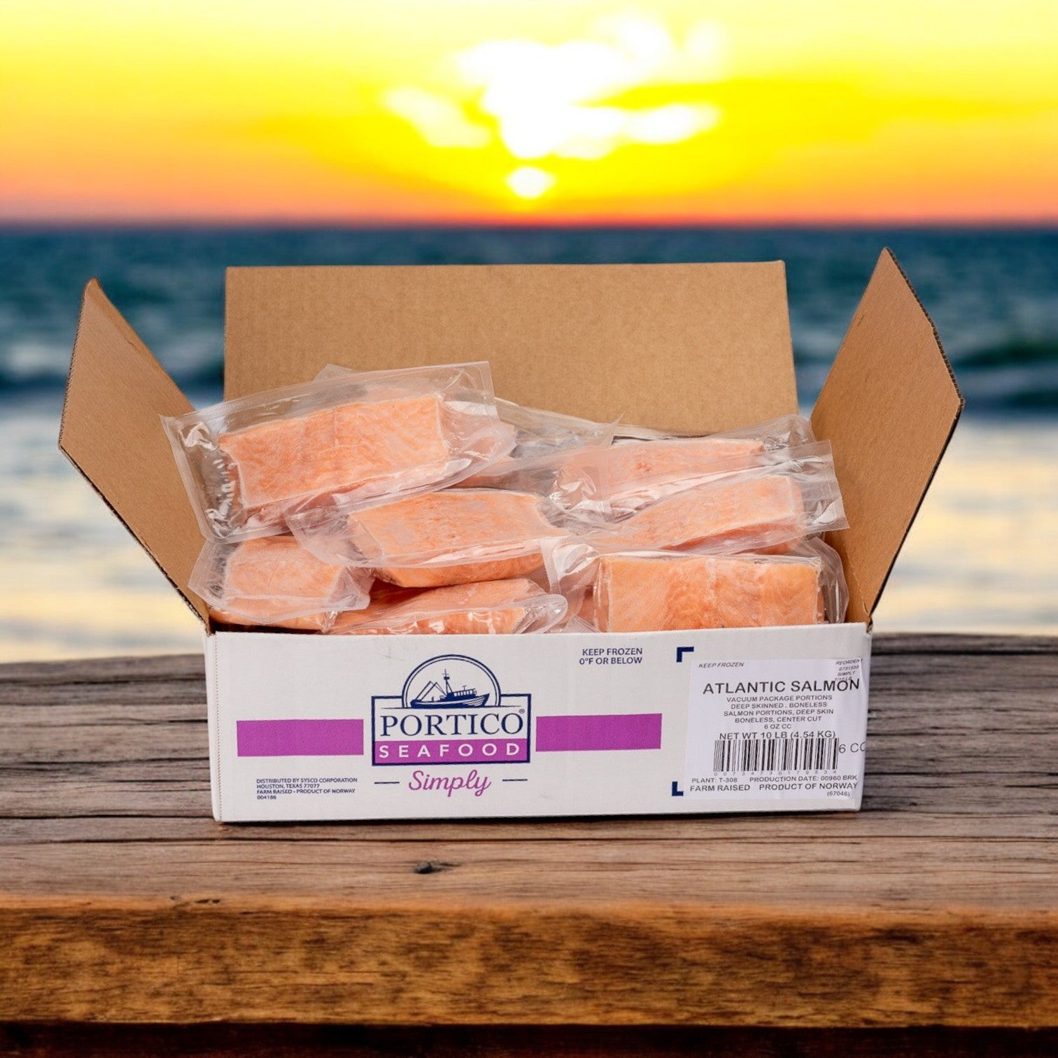 Portico Classic Seafood presents Atlantic Salmon Portions, Skinless, 4 oz - Norwegian in a 10 lbs box, displayed on a wooden surface against an ocean sunset. Packed with Omega-3 fatty acids for a nutritious and tasty meal.