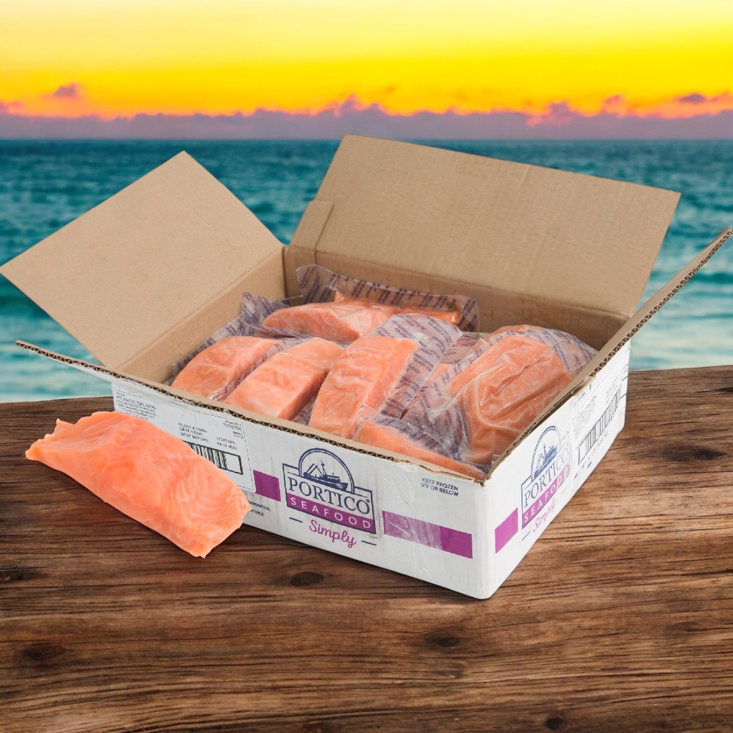 A box of Portico Classic Seafood's Salmon Atlantic Portioned Skinless 6oz sits on a wooden table, beautifully set against an ocean sunset backdrop, offering a rich source of Omega-3 fatty acids.