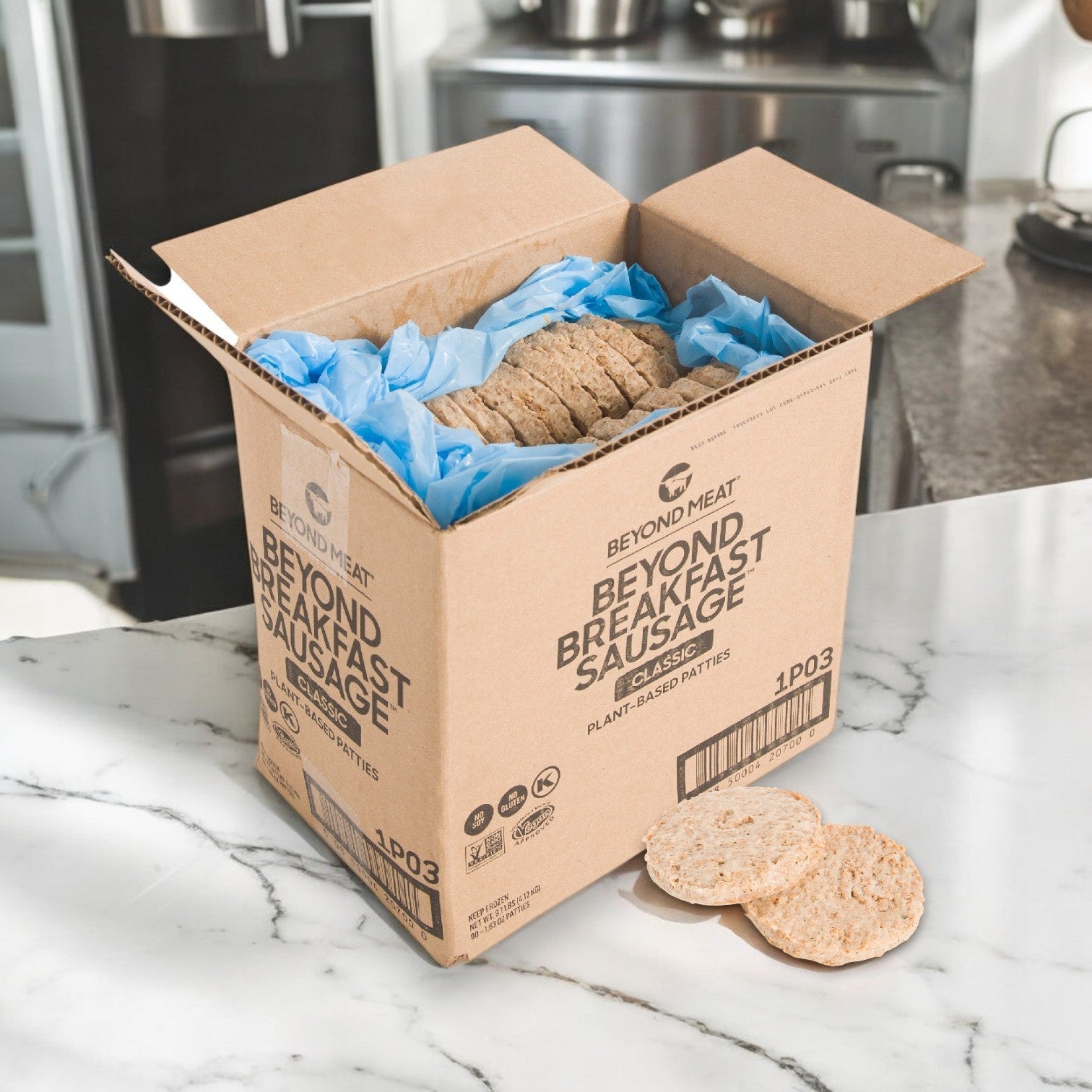 An open box of Beyond Meat Sausage Breakfast Patty Vegan – 90/1.7 OZ with blue packing paper sits on a kitchen counter. Three patties are displayed on the marble surface, highlighting a delicious plant-based protein option from Beyond Meat.