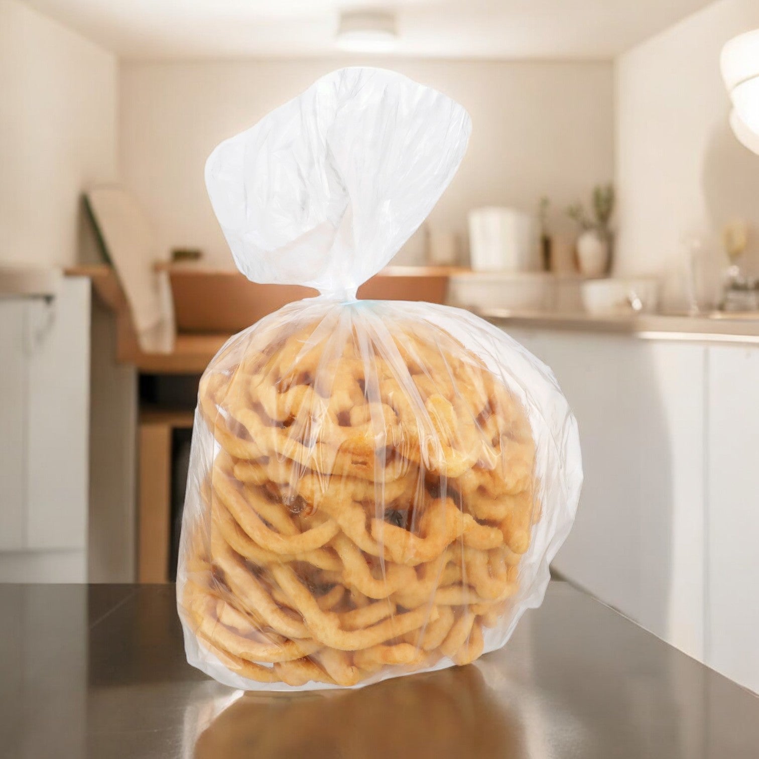 A clear plastic bag filled with ring-shaped snacks, akin to J&J Snacks' Cake Funnel Baked, 24-count, rests on a reflective kitchen countertop.