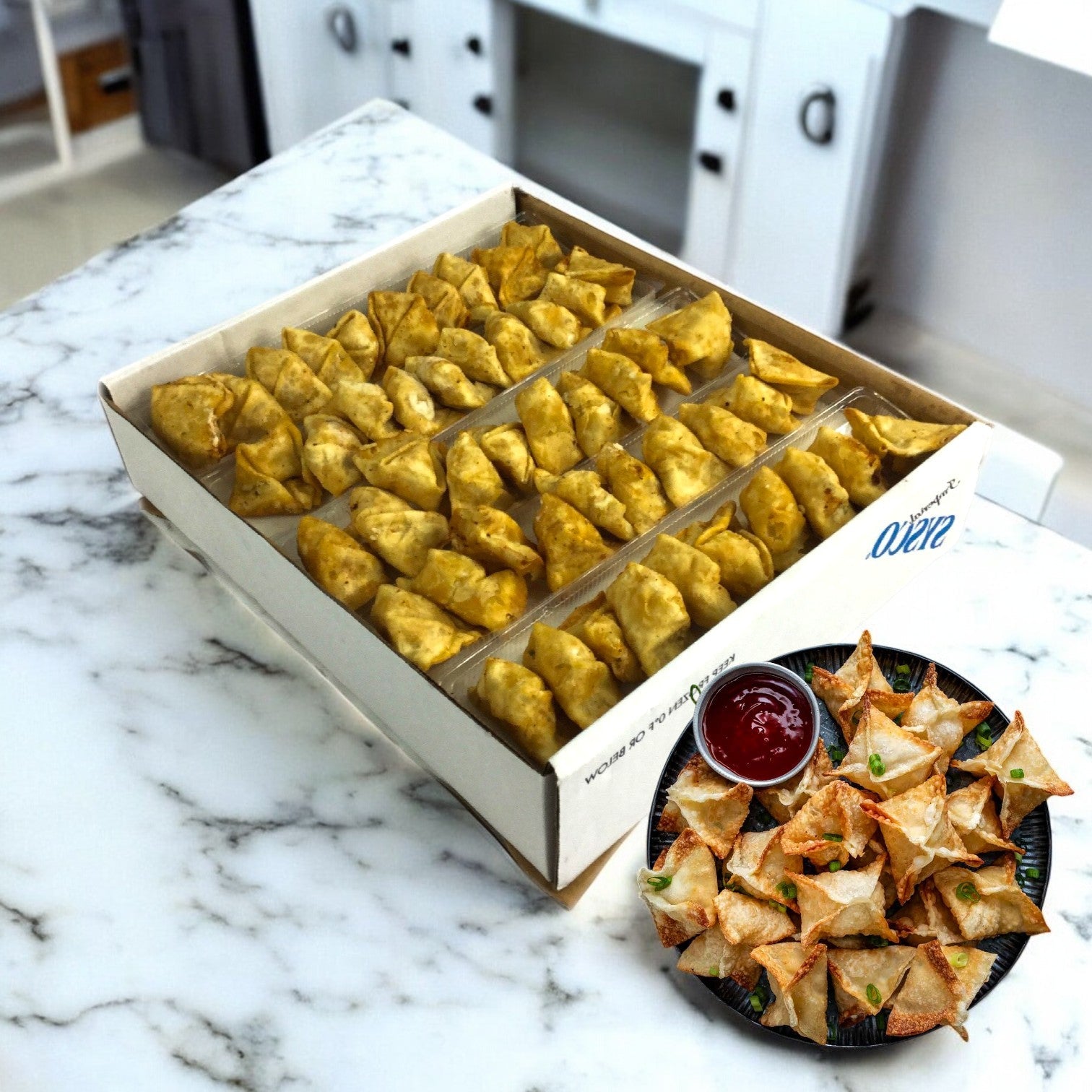 A box of Sysco's Crab Rangoon appetizer, featuring crispy wontons and a savory dipping sauce, elegantly arranged on a marble countertop.