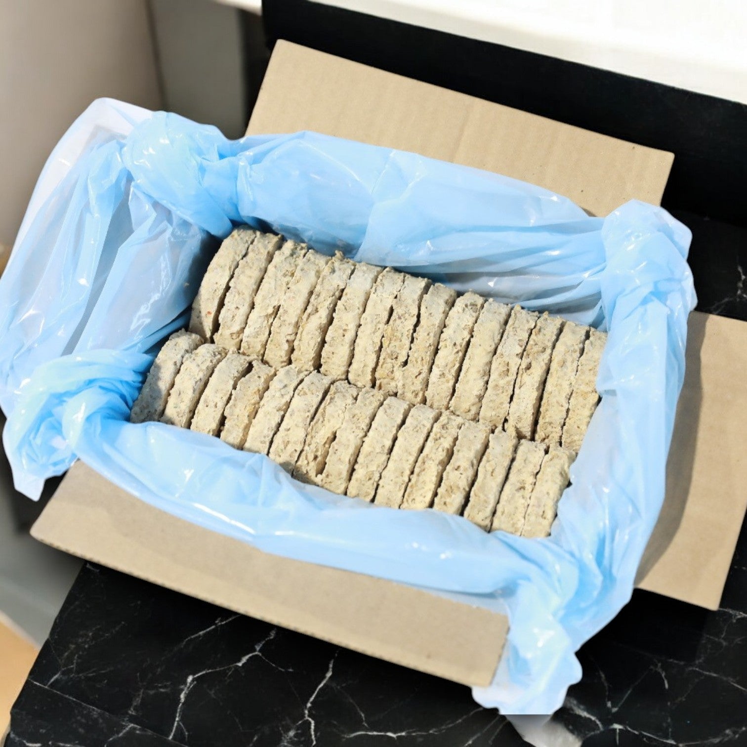 A cardboard box from Beyond Meat contains 90 neatly stacked light gray textured discs reminiscent of vegan breakfast patties, each lined with blue plastic.