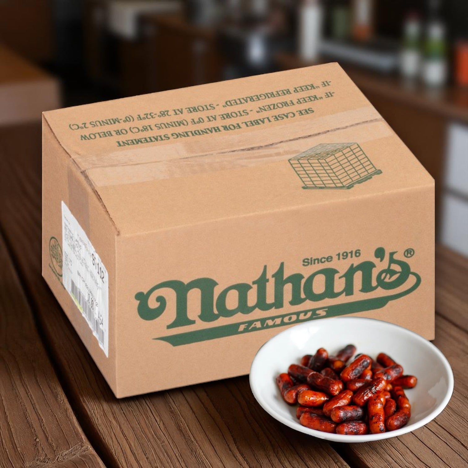 A box of Nathan’s Famous Cocktail Franks – 1200 Count sits on a wooden surface beside a white bowl of red beans, highlighting the brand's signature mini beef franks.