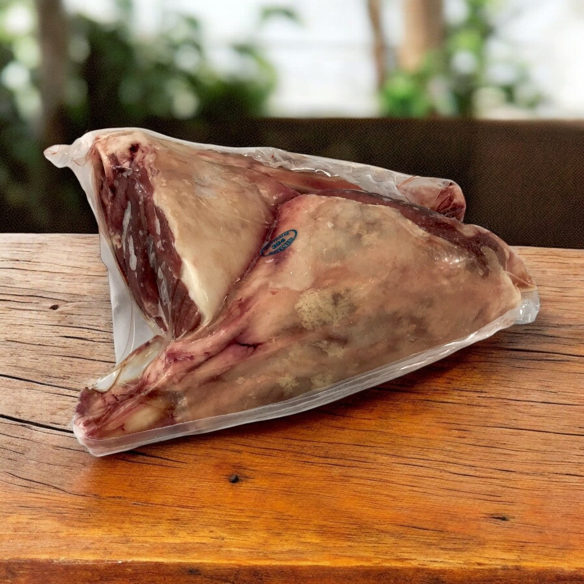 The Butcher's Block by Sysco features vacuum-sealed premium quality Halal Lamb Hindshank, available in a 20-pack of 16 oz each, perfect for versatile cooking and preparation on any wooden table.