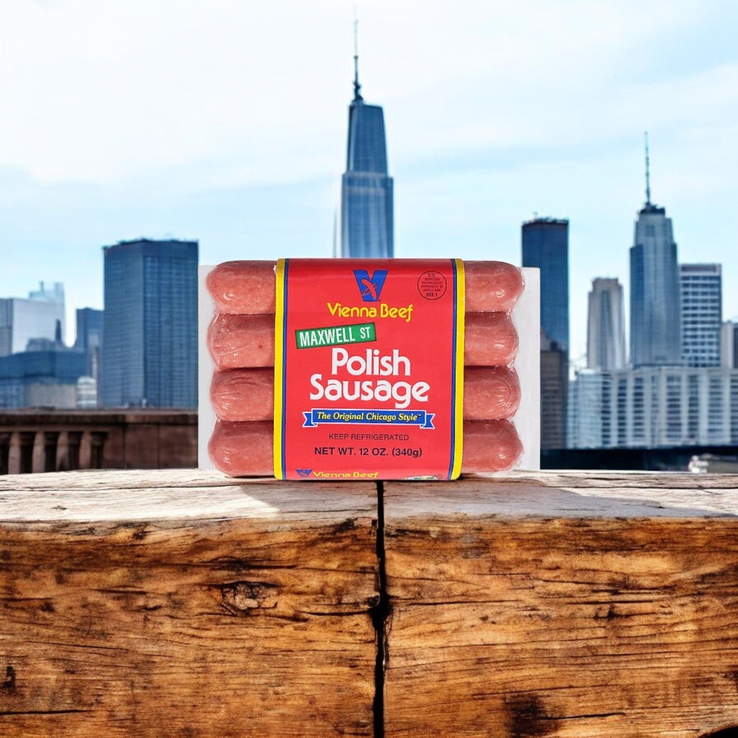 A Vienna Beef 3-Pack Combo with 16 Beef Franks & 8 Maxwell St. Polish Sausages sits on a wooden surface, capturing the authentic Chicago taste, with a city skyline in the backdrop.