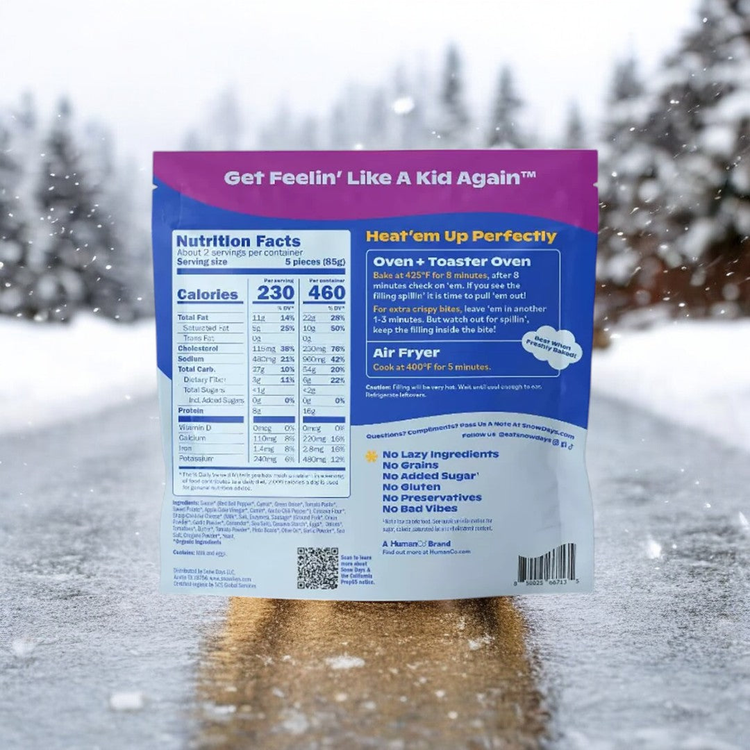A Snow Days Frozen Organic Taco Pizza Bites package is displayed on a snowy road, highlighting the nutrition facts. The text states: "Get Feelin' Like A Kid Again," along with cooking instructions for oven, toaster, and air fryer. Enjoy this versatile snack—a delightful blend of flavors that's both playful and delicious.