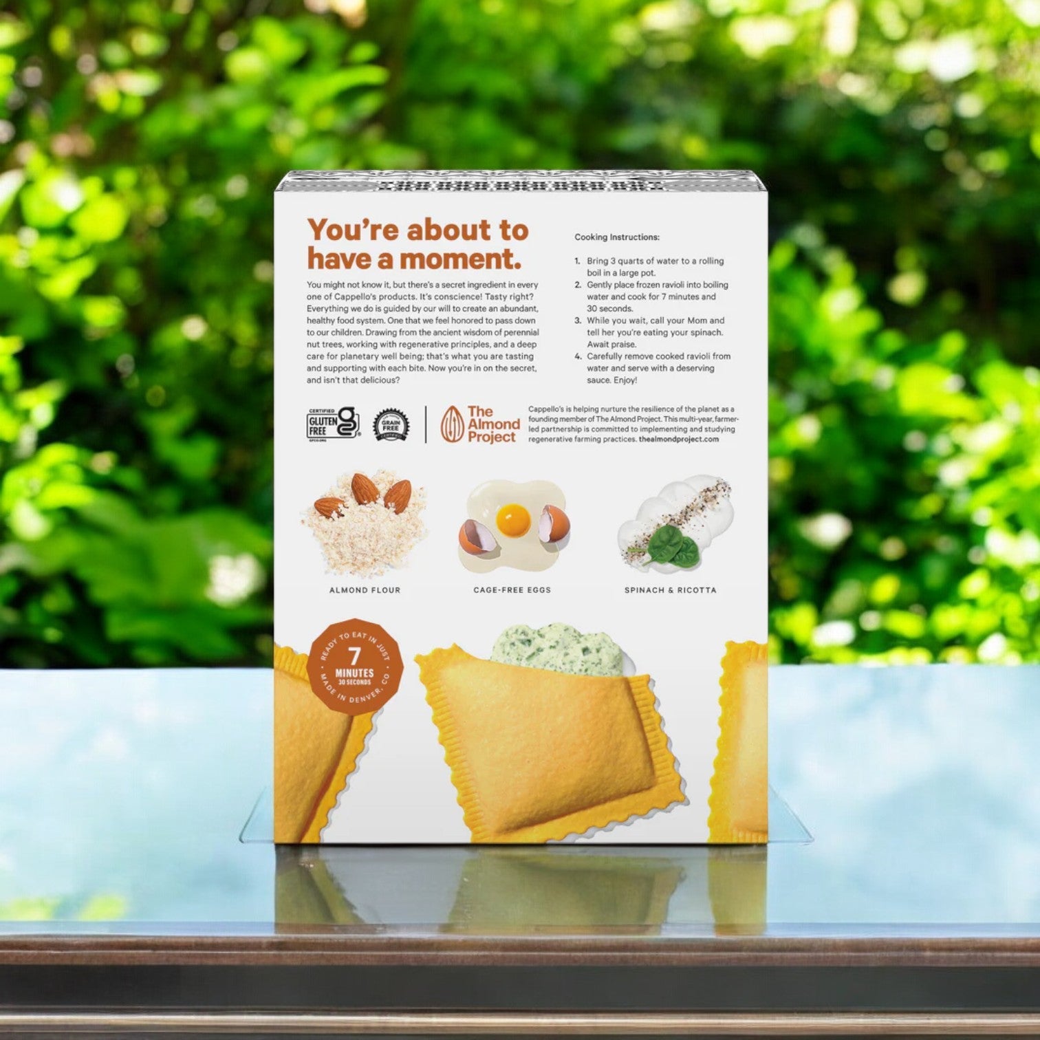 A box of Cappello's Spinach & Cheese Ravioli, 9.9 oz., sits on a reflective surface, showcasing its ingredients and cooking instructions.
