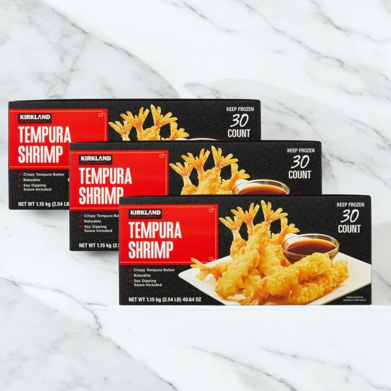 Three boxes of Kirkland Signature Tempura Shrimp, each with 30 pieces (2.35 lbs per box), are displayed on a white marble surface—ideal for Kirkland Signature fans seeking a tasty appetizer.