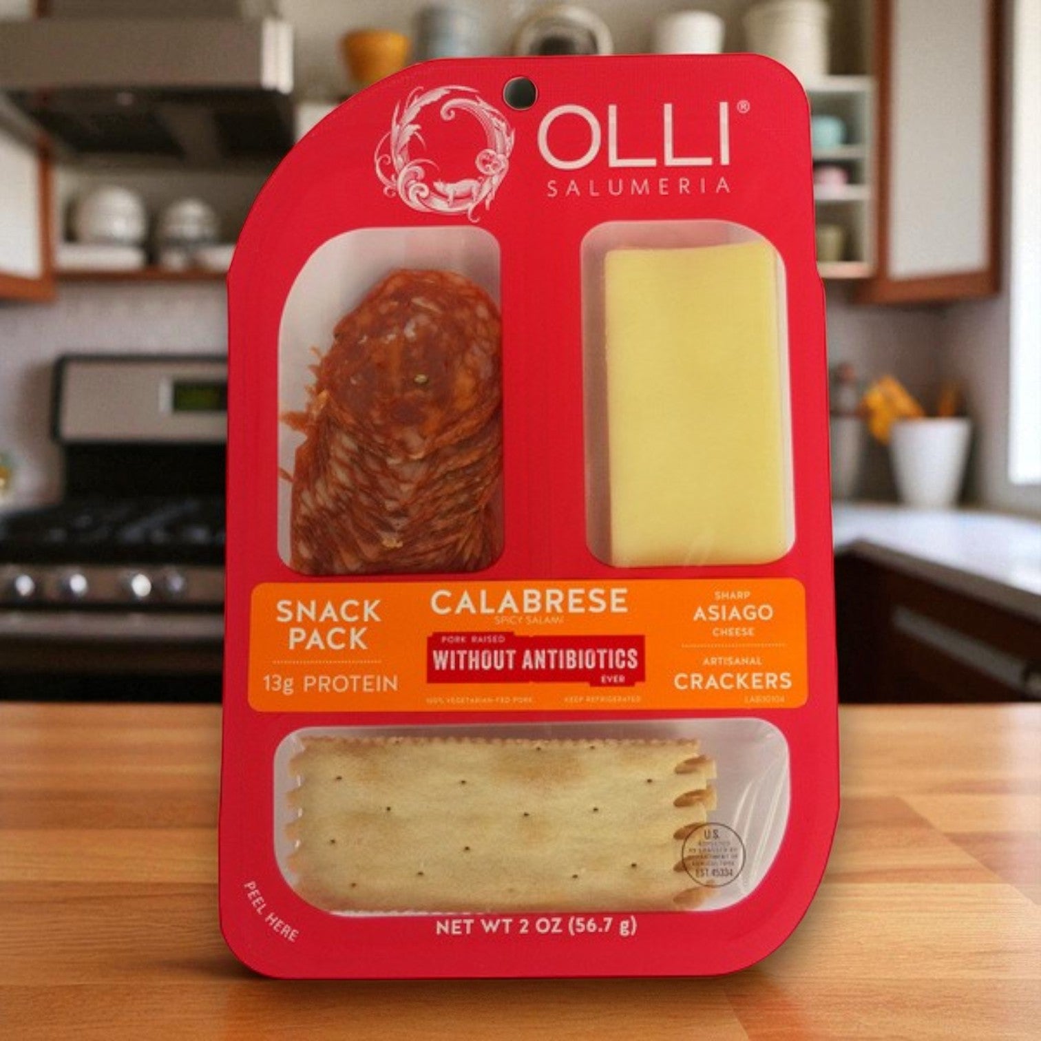 A 10-pack of Olli Salumeria Calabrese Salami & Asiago Cheese Snack Packs (2 oz each) by Olli is displayed on a kitchen counter.