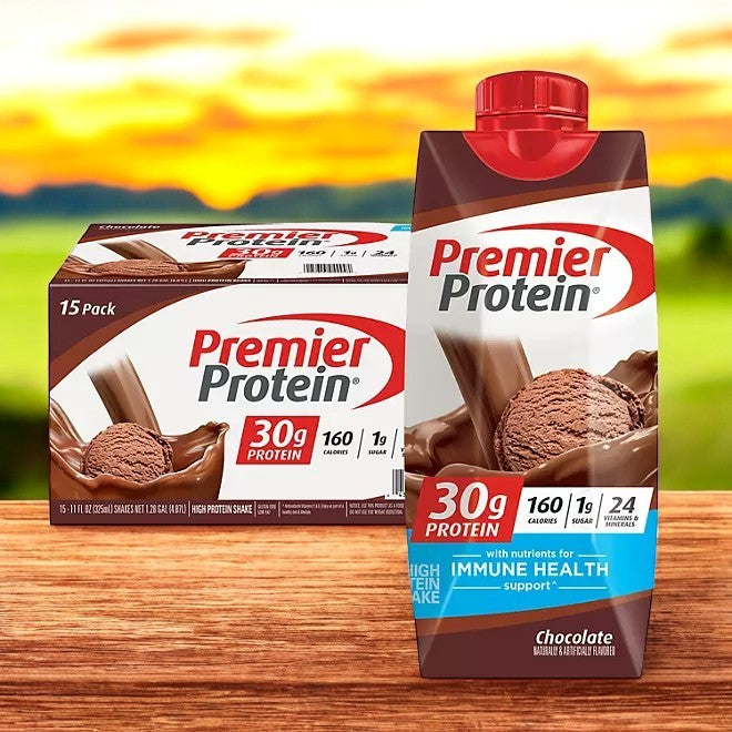 The packaging for the Premier Protein 30g High Protein Shake, Chocolate flavor, features a 15-pack case with individual containers holding 11 fl. oz. each. The shake provides 30 grams of protein, only 160 calories, and contains just 1 gram of sugar. With added benefits supporting immune health, it is an excellent option for meal replacement or convenient on-the-go nutrition.