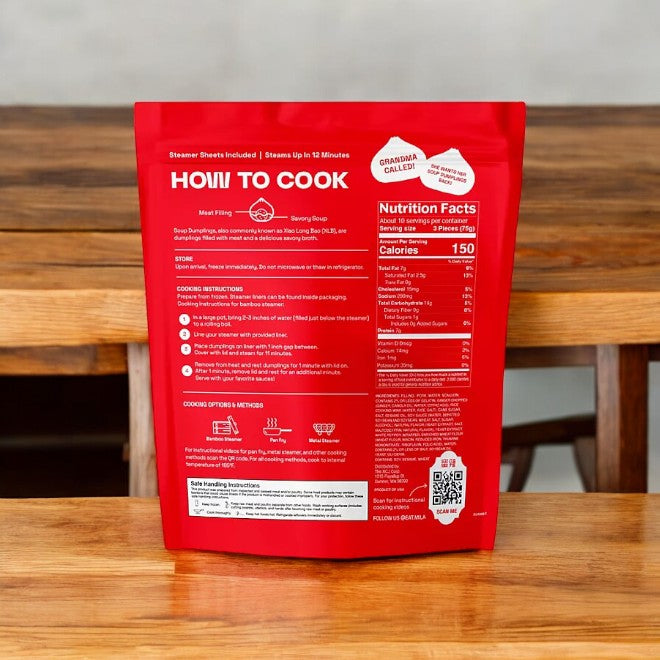 Mila's frozen dumpling packaging, set against a wooden table, includes cooking instructions and nutritional facts, along with a "Grandma Approved" label. Inside the red package, you can enjoy the delicious MiLa Pork Soup Dumplings—filled with savory pork soup that captures the essence of xiao long bao in every bite. Each pack contains 3 bags of 31 dumplings each, totaling 27.3 oz.
