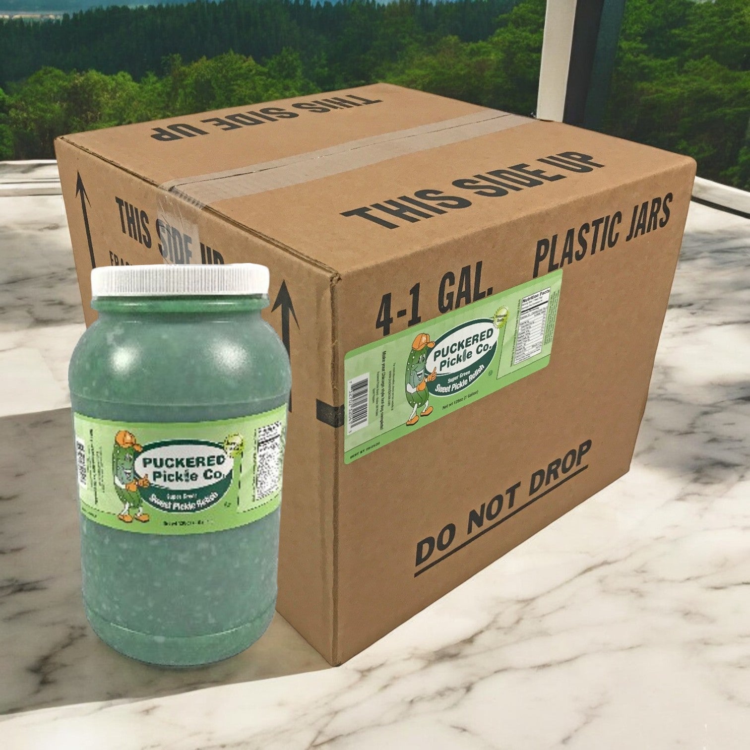 A gallon jar of Puckered Pickle Co. Sweet Green Bright Relish sits next to a marked box on a marble surface, offering a tangy flavor ideal for enhancing your foodservice operations.