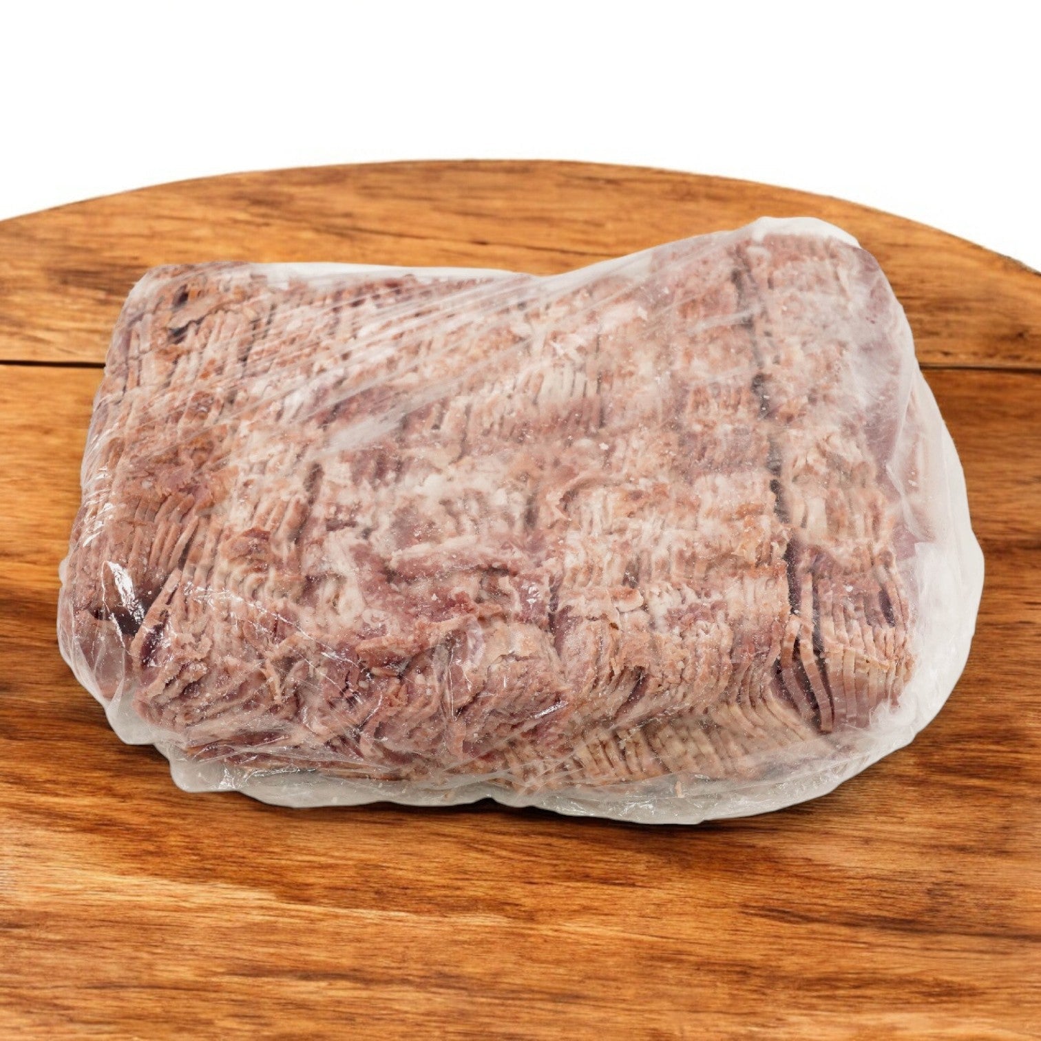 A pack of Greco & Sons Halal Beef Bacon Strips, wrapped in clear plastic, rests on a wooden surface.