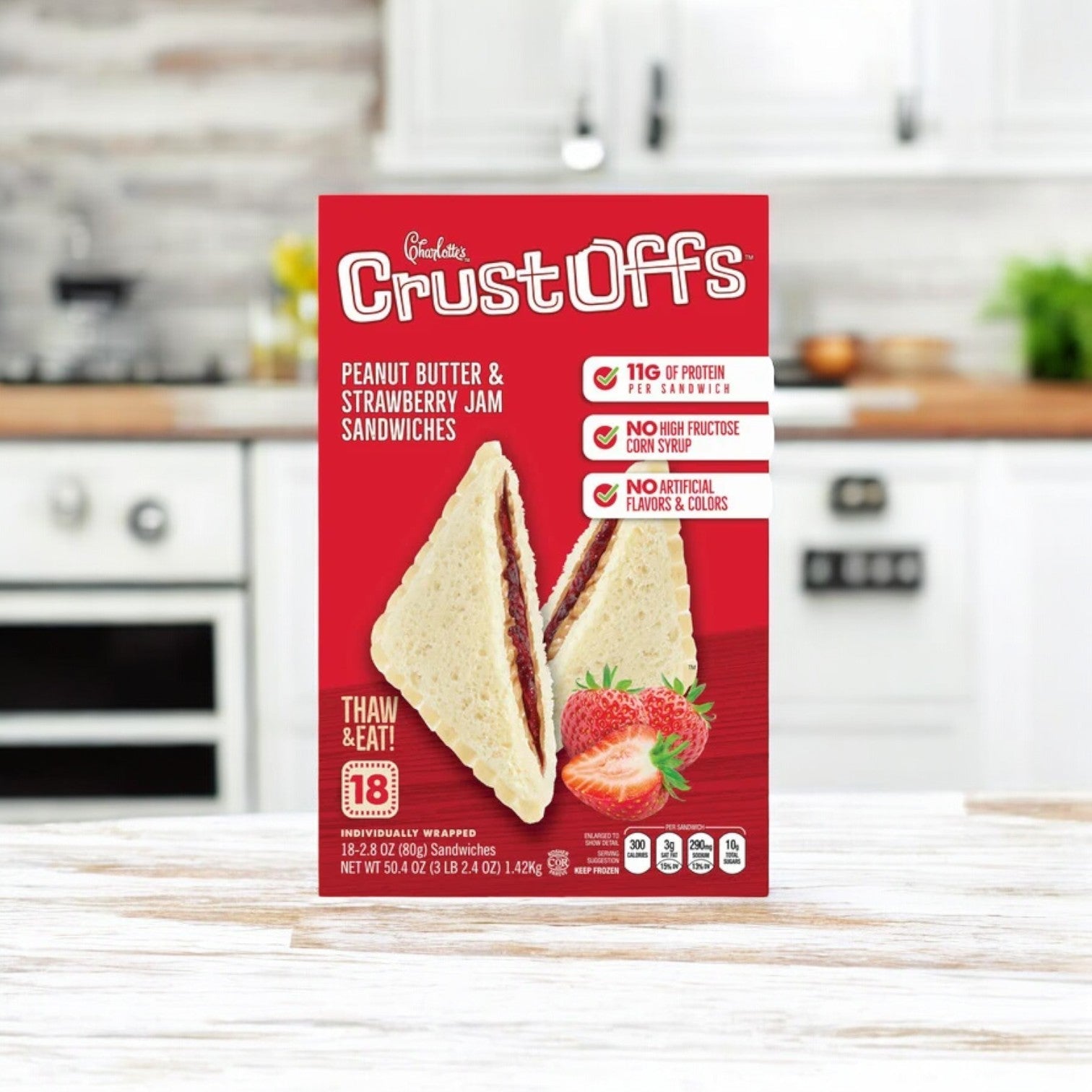 Charlotte's Crust Offs Sandwiches, Peanut Butter & Strawberry Jam (2.2 oz., 3 Box) from Crust Off's sit invitingly on the kitchen counter against a softly blurred background, enhancing their appeal.