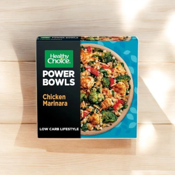 The Healthy Choice Power Bowls Chicken Marinara With Riced Cauliflower, offered in 9.25 oz. and an 8-count pack, is packaged for a low-carb lifestyle and elegantly presented on a wooden surface.