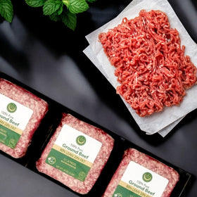Crescent Foods' 3 lbs packs of Halal Ground Beef labeled as 80% lean are neatly arranged. Beside them, some raw meat is displayed on parchment, adorned with a fresh mint sprig in the corner, inviting culinary creativity.
