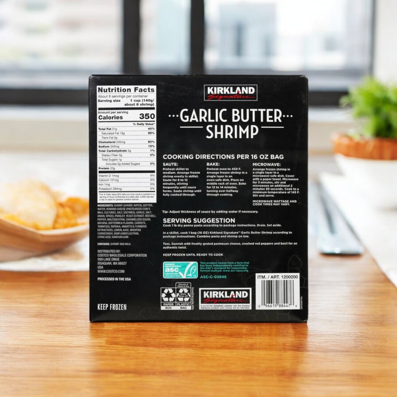 A package of Kirkland Signature Garlic Butter Shrimp, featuring three bags in a two-count offering, is displayed on a wooden table. Ideal for seafood enthusiasts, the back label includes simple preparation instructions, nutritional information, and serving ideas.