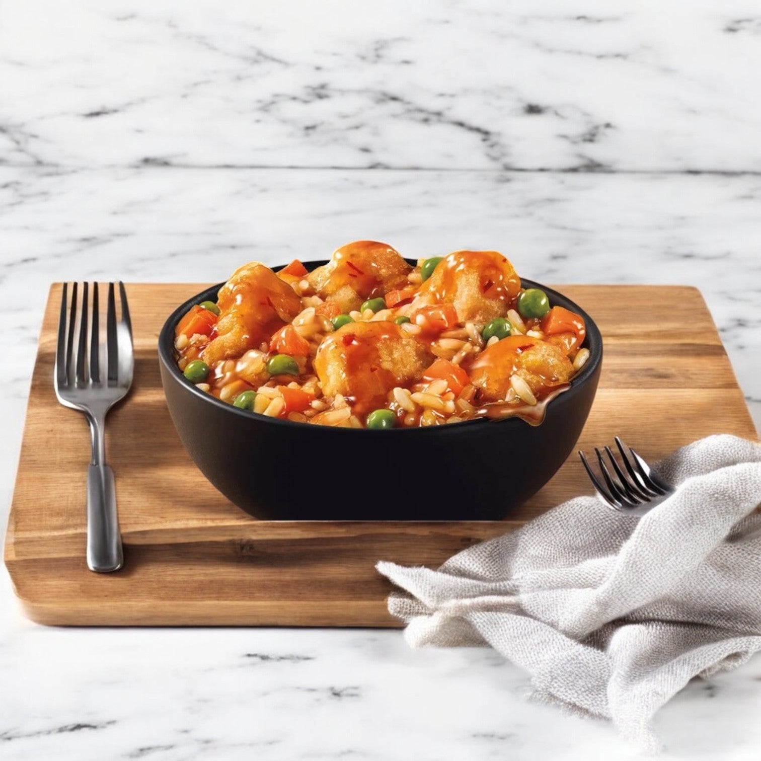 A bowl of Marie Callender's Sweet & Citrusy Orange Chicken, featuring rice, peas, and carrots on a wooden board, evokes the style of a Smart Ones Frozen Meal, with a fork and napkin.