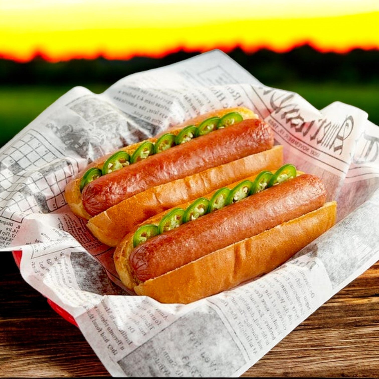 Two Nathan's Famous Franks packed with 100% beef are topped with sliced jalapeños, presented in a newspaper-lined red basket, embodying the sunset's essence.