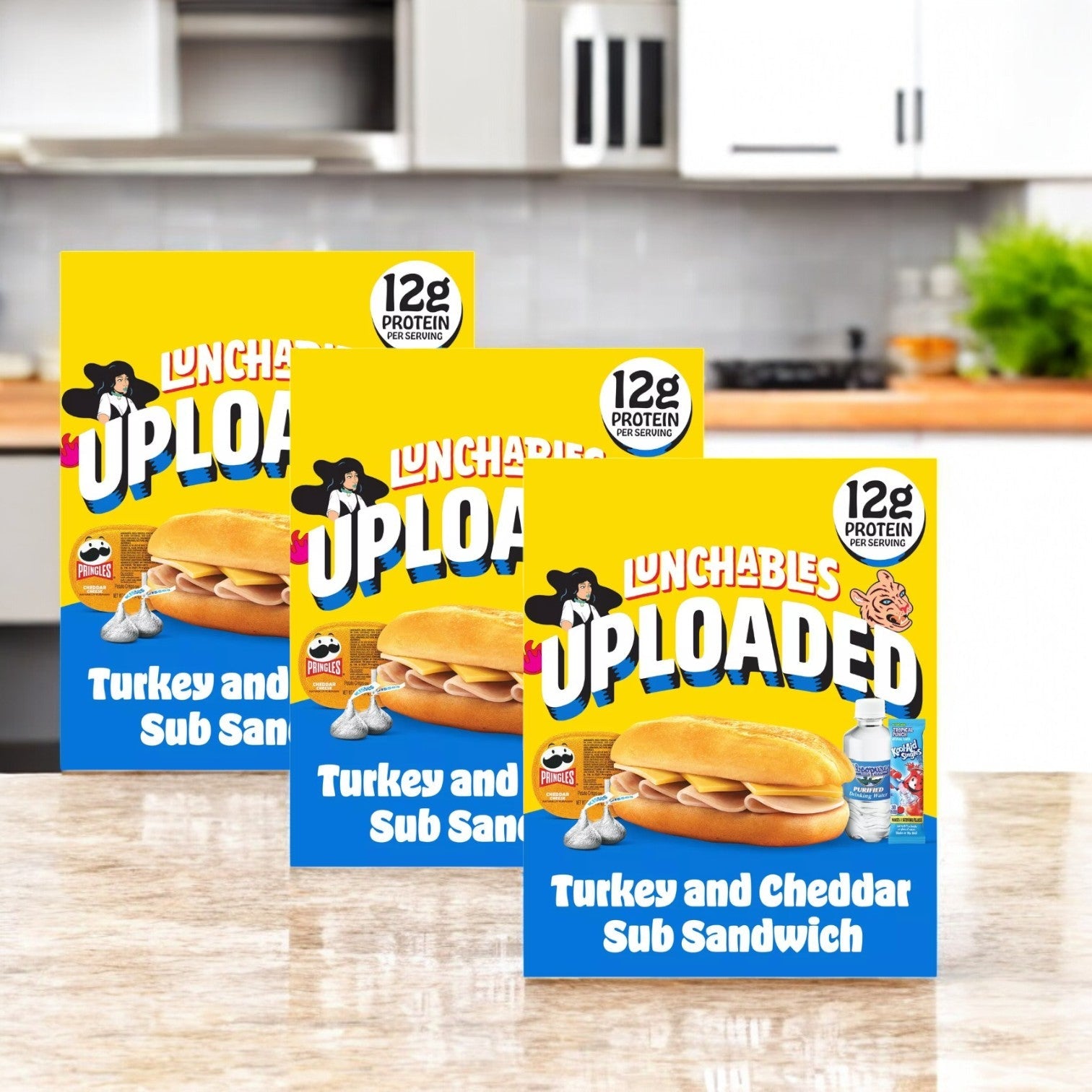 Three boxes of Lunchables 6-Inch Turkey & Cheddar Cheese Sub Sandwich Kids Lunch Meal are on the kitchen counter, each with "12g protein" and a sandwich with a water bottle, ideal for convenient on-the-go meals.