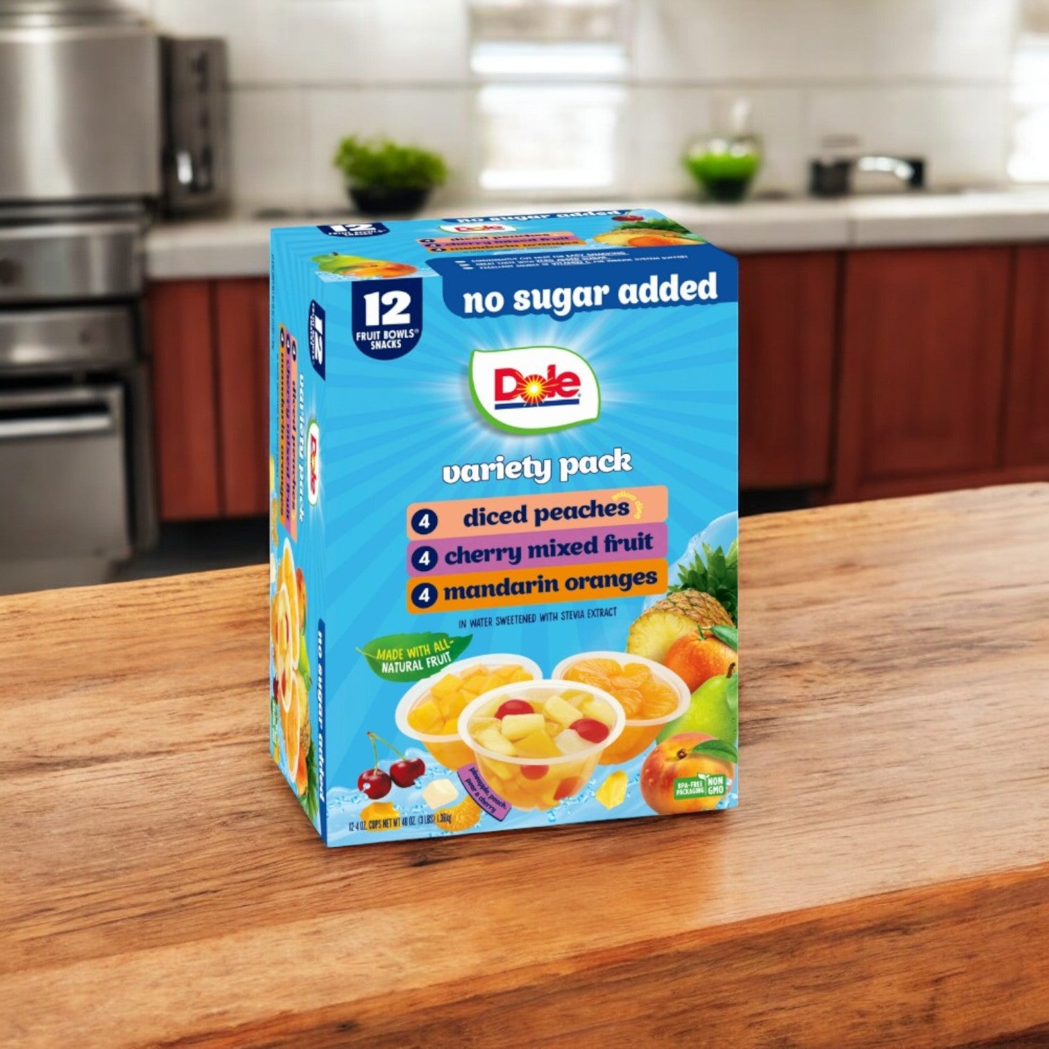 On the kitchen counter is a Dole Fruit Bowls Snack pack by Dole, a healthy option featuring a variety of diced peaches, cherry mixed fruit, and mandarin oranges. Enjoy 12 refreshing cups in total.