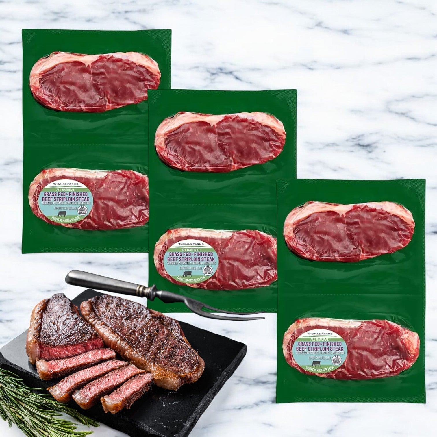 Three vacuum-sealed packs of Thomas Farms Grass Fed New York Strip Steaks (6 total) are on a marble surface, with one cooked steak partially sliced, garnished with rosemary and a fork.