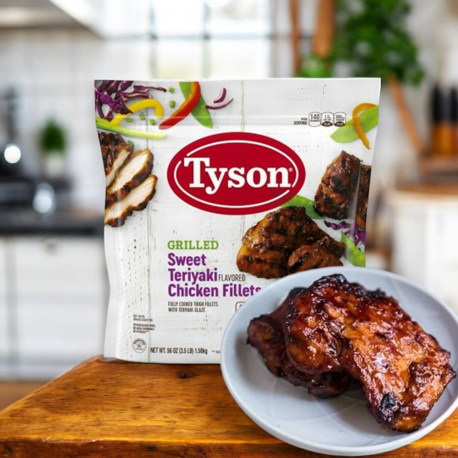 A bag of Tyson Grilled Sweet Teriyaki Flavored Chicken Fillets, 3.5 lb., sits on the kitchen counter, with a plate of glazed fillets in front, showcasing a delicious testament to Asian-inspired cuisine.