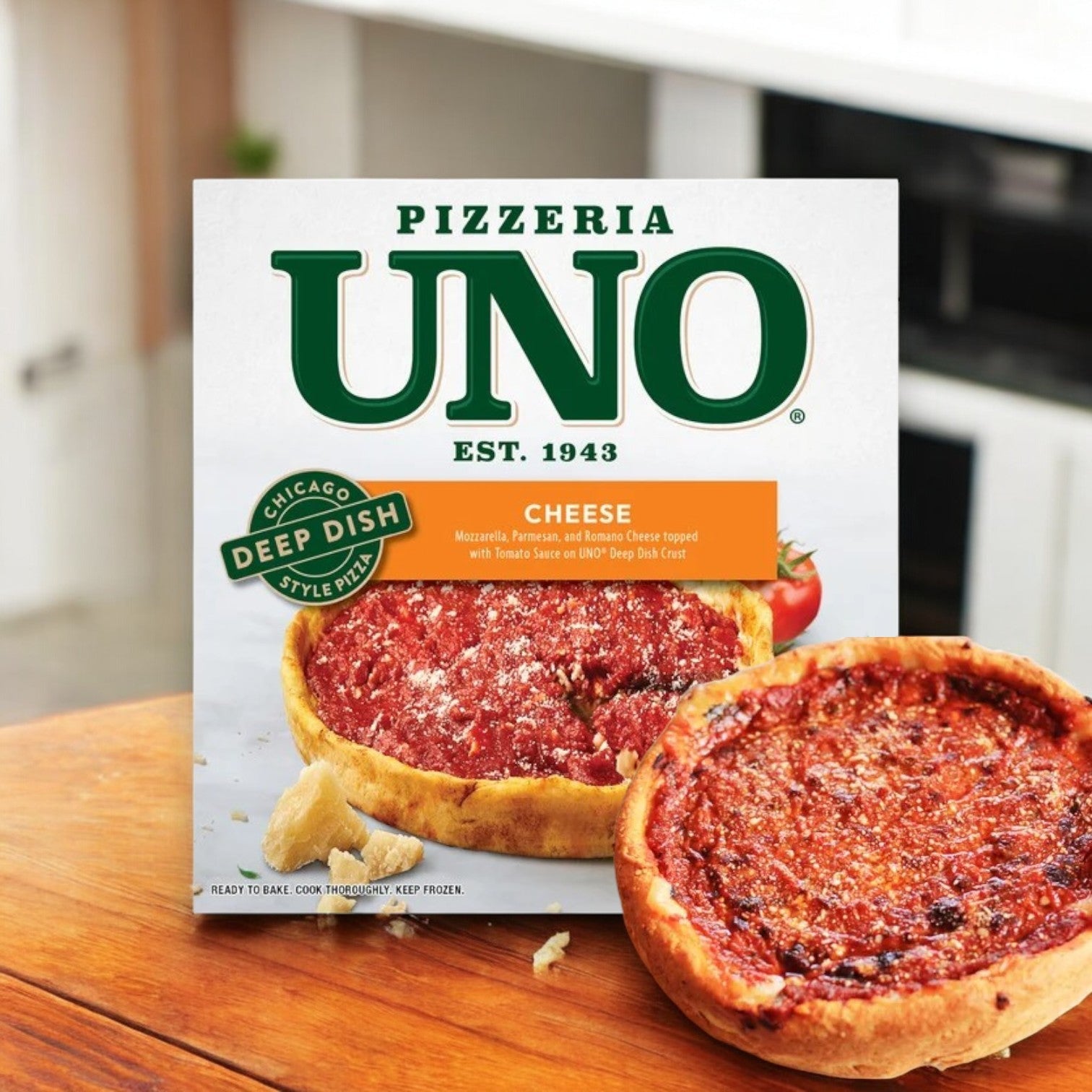 An Uno Chicago Style Deep Dish Cheese Pizza, 26 oz., by Pizzeria Uno rests in an open box on the table, its buttery crust and gooey mozzarella enticingly peeking out.