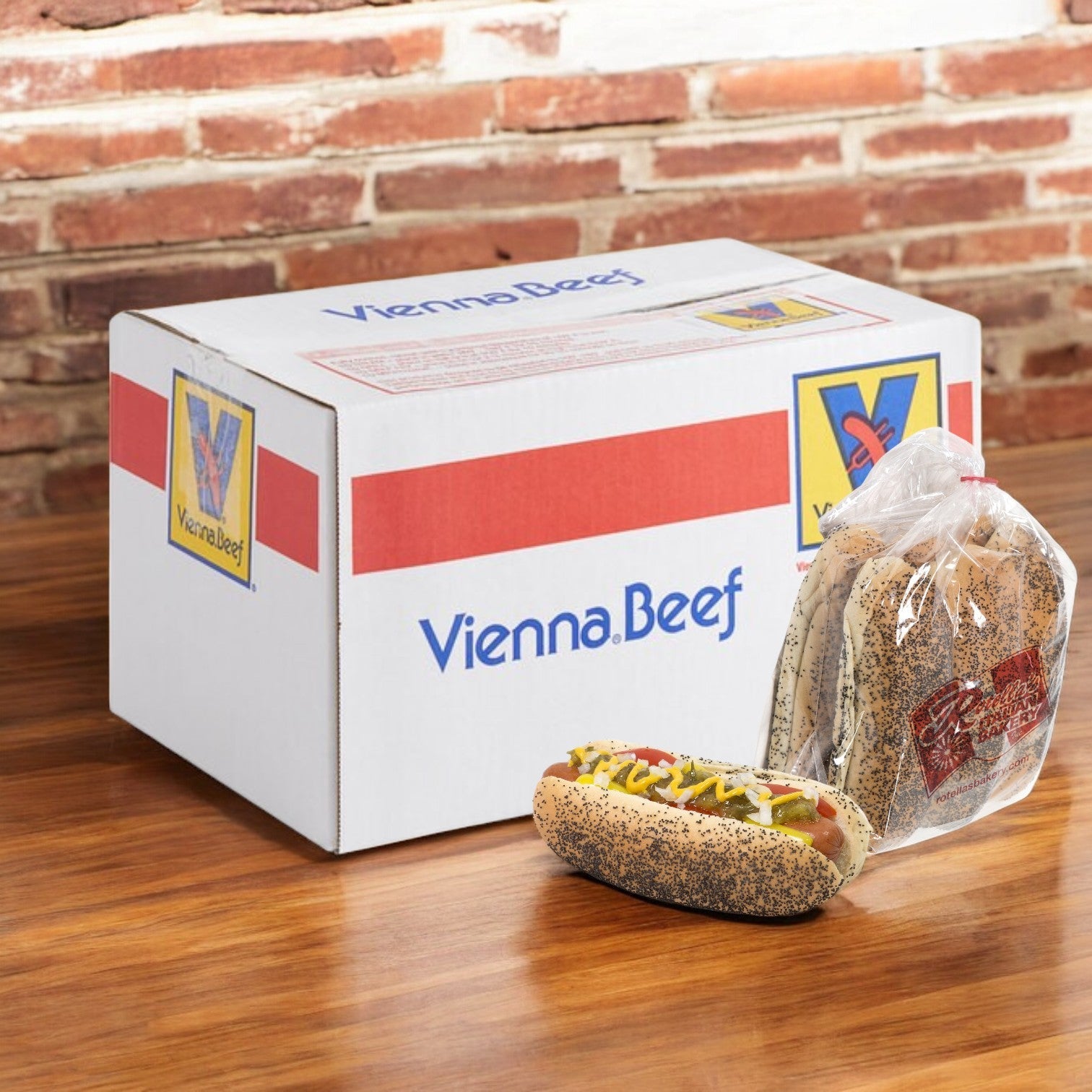 A box displaying the "Vienna Beef Hot Dog Kit- 60 Hot Dogs and 60 Buns!" is on the table, with a Chicago-style hot dog nestled in a Rotella’s Poppyseed Bun right next to it. The scene, set against a rustic brick wall, perfectly captures the essence of classic Vienna Beef hot dogs poised to thrill your taste buds.