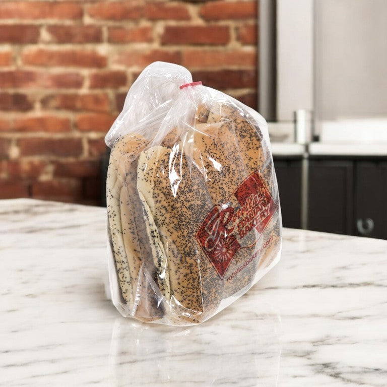A Vienna Beef Franks and Sesame Buns package is on a marble countertop, evoking the essence of sesame buns paired with Chicago hot dogs, with a brick wall in the background.