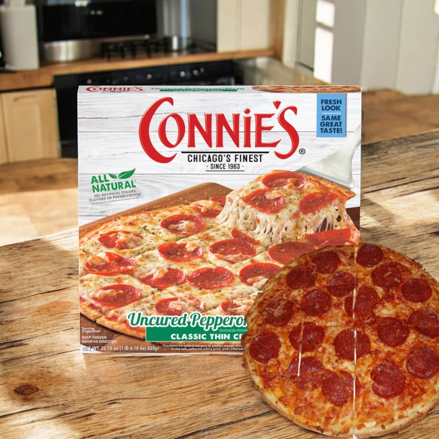 A frozen pepperoni pizza box labeled "Connie's Chicago's Finest" sits on a wooden table beside a cooked thin crust pizza. Enjoy a quick, convenient meal with the delicious taste of Connie's Pizza Classic Thin Crust Uncured Pepperoni right at home.