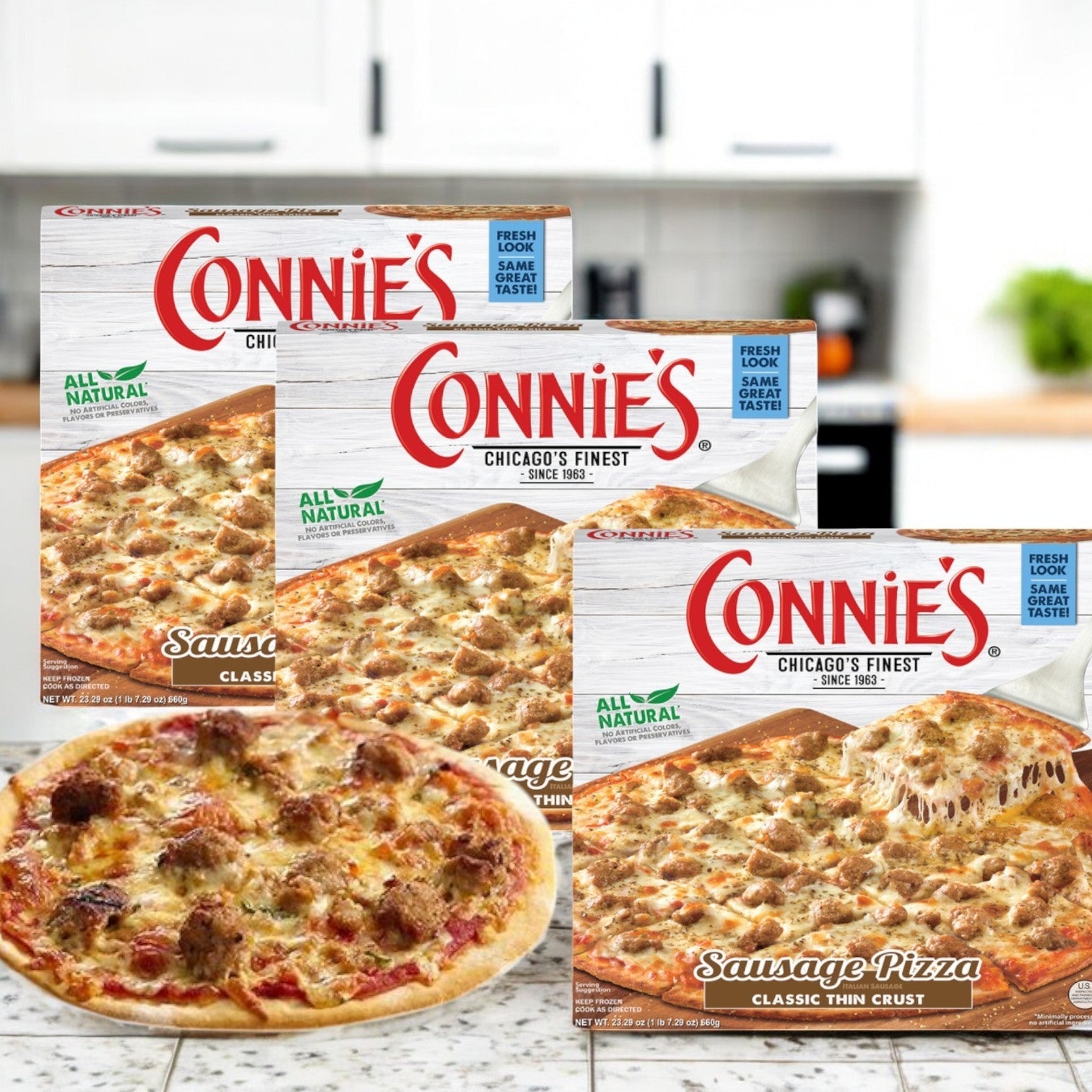 Three boxes of Connie's Pizza, Sausage, Classic Thin Crust (23.29 oz., 3 Pack) are on the kitchen counter with one savory sausage pizza perfectly cooked in front.