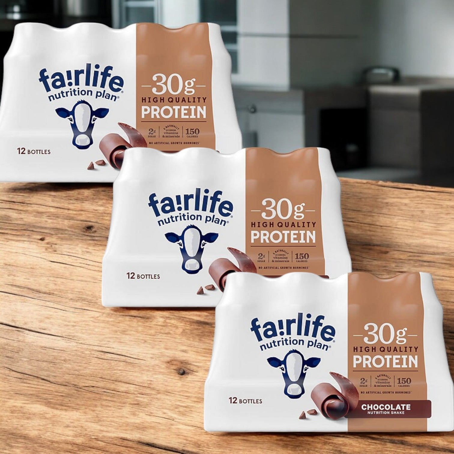 Three cases of Fairlife Nutrition Plan Chocolate Bottles are shown on a wooden table. Each case includes 12 bottles, each offering 30g of ultra-filtered milk protein per serving.