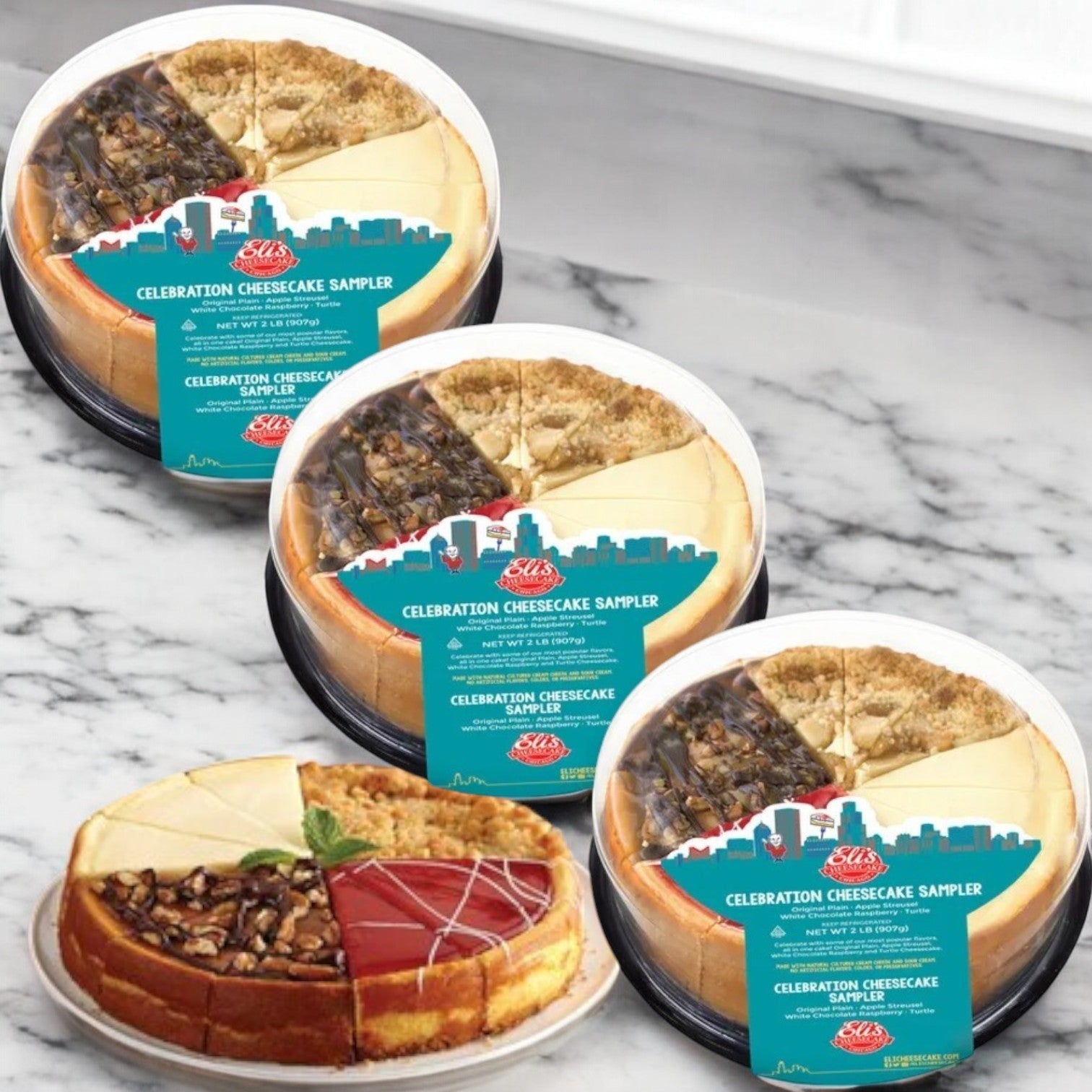 Eli's Cheesecake Celebration Sampler, 32 oz. - 3 Count takes center stage with its sliced cheesecake on a plate, offering four delightful varieties that make each piece a celebration of flavor.